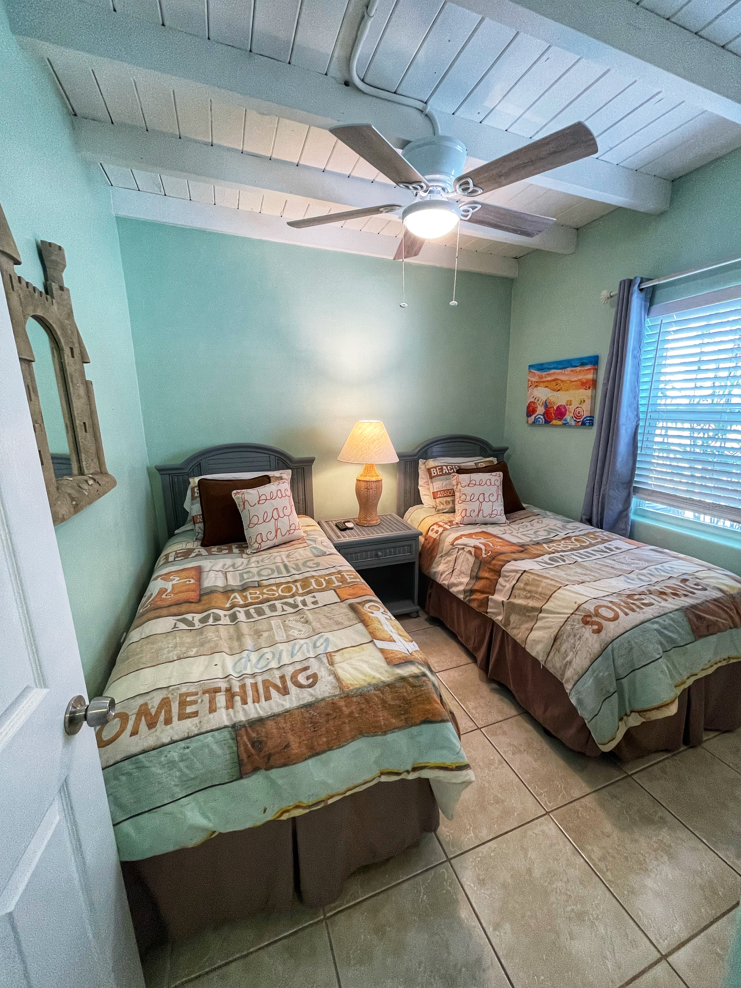 Unit 101 beach-themed twin bedroom
